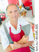 a butcher is with knives. Стоковое фото, агентство Ingram Publishing / Фотобанк Лори