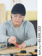 portrait of happy female woodworker drafting new project at workshop. Стоковое фото, агентство Ingram Publishing / Фотобанк Лори
