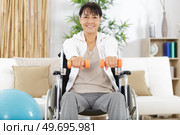 woman on wheelchair holding weights. Стоковое фото, агентство Ingram Publishing / Фотобанк Лори