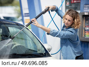woman holding green nozzle at gas station. Стоковое фото, агентство Ingram Publishing / Фотобанк Лори