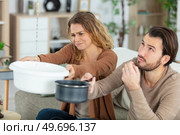 couple catching leaking water in a basin and saucepan. Стоковое фото, агентство Ingram Publishing / Фотобанк Лори