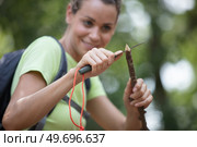 skillful woman whittling stick in forest. Стоковое фото, агентство Ingram Publishing / Фотобанк Лори