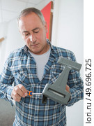man fixing objet with screwdriver. Стоковое фото, агентство Ingram Publishing / Фотобанк Лори