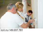 industrial painting worker giving advice to the apprentice. Стоковое фото, агентство Ingram Publishing / Фотобанк Лори