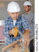 senior tradesman using hacksaw. Стоковое фото, агентство Ingram Publishing / Фотобанк Лори