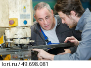 apprentice learning to operate a machine. Стоковое фото, агентство Ingram Publishing / Фотобанк Лори