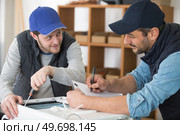 electrician with apprentice working in new home. Стоковое фото, агентство Ingram Publishing / Фотобанк Лори