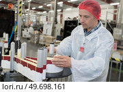 man in bottling plant working on labelling machine. Стоковое фото, агентство Ingram Publishing / Фотобанк Лори