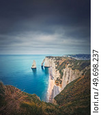 Falaise d’Aval limestone cliffs washed by La Manche channel waters. Beautiful coastline view to the famous rock Aiguille of Etretat in Normandy, France. Стоковое фото, агентство Ingram Publishing / Фотобанк Лори