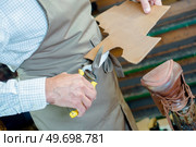 male worker cobbler cutting cardboard. Стоковое фото, агентство Ingram Publishing / Фотобанк Лори