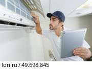 young contractor working carefully and seriously at clients office. Стоковое фото, агентство Ingram Publishing / Фотобанк Лори