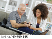 young woman and senior man chating with family using tablet. Стоковое фото, агентство Ingram Publishing / Фотобанк Лори