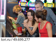 beautiful young people near slot machine in a casino. Стоковое фото, агентство Ingram Publishing / Фотобанк Лори