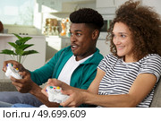 multiracial couple with joysticks playing video game. Стоковое фото, агентство Ingram Publishing / Фотобанк Лори