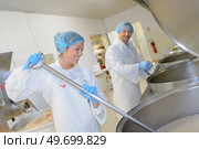 two factory workers working in a factory. Стоковое фото, агентство Ingram Publishing / Фотобанк Лори