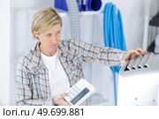 handywoman in flannel shirt fixing intercom. Стоковое фото, агентство Ingram Publishing / Фотобанк Лори