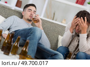 battered woman and drunk man on sofa at home. Стоковое фото, агентство Ingram Publishing / Фотобанк Лори