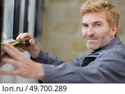 man measuring window prior to installation of roller shutter outdoors. Стоковое фото, агентство Ingram Publishing / Фотобанк Лори
