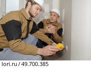 technician metering socket voltage with digital multimeter. Стоковое фото, агентство Ingram Publishing / Фотобанк Лори
