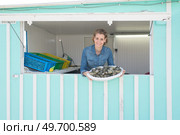female seller selling fresh fish and chilled seafood at market. Стоковое фото, агентство Ingram Publishing / Фотобанк Лори