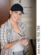 female manual worker writing on clipboard. Стоковое фото, агентство Ingram Publishing / Фотобанк Лори
