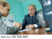 client putting signature on funeral service contract. Стоковое фото, агентство Ingram Publishing / Фотобанк Лори