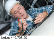 electrician changing halogen lamp in ceiling light in room. Стоковое фото, агентство Ingram Publishing / Фотобанк Лори
