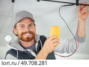 electrician using a multimeter to test spotlight connections. Стоковое фото, агентство Ingram Publishing / Фотобанк Лори