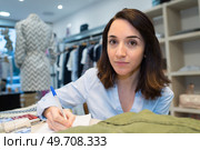 female shop keeper making notes. Стоковое фото, агентство Ingram Publishing / Фотобанк Лори