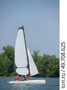 young couple steering a catamaran. Стоковое фото, агентство Ingram Publishing / Фотобанк Лори