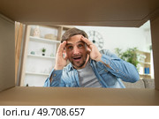 suprised man looking for something inside box. Стоковое фото, агентство Ingram Publishing / Фотобанк Лори