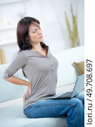 Woman with laptop stretching aching back. Стоковое фото, агентство Ingram Publishing / Фотобанк Лори