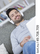 happy relaxed young man listening to music at home. Стоковое фото, агентство Ingram Publishing / Фотобанк Лори