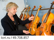 a woman checking the violins. Стоковое фото, агентство Ingram Publishing / Фотобанк Лори