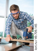 man cutting wood block with fretsaw. Стоковое фото, агентство Ingram Publishing / Фотобанк Лори