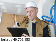 architect checking insulation during house construction. Стоковое фото, агентство Ingram Publishing / Фотобанк Лори