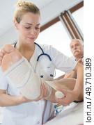female doctor bandaging leg of patient in hospital. Стоковое фото, агентство Ingram Publishing / Фотобанк Лори