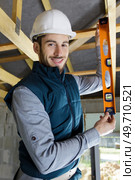 happy construction worker checking vertical level of column. Стоковое фото, агентство Ingram Publishing / Фотобанк Лори