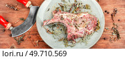 Raw pork steak Tomahawk marinated in spicy herbs on wooden background.. Raw pork steak Tomahawk. Стоковое фото, агентство Ingram Publishing / Фотобанк Лори