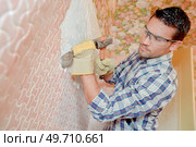 male worker is chiseling a wall. Стоковое фото, агентство Ingram Publishing / Фотобанк Лори