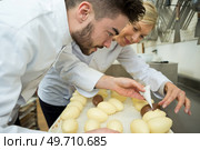 two chocolatier apprentice decorating egg chocolate. Стоковое фото, агентство Ingram Publishing / Фотобанк Лори
