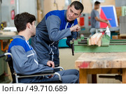 disabled worker in wheelchair in factory. Стоковое фото, агентство Ingram Publishing / Фотобанк Лори