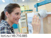 woman putting up a light for a senior. Стоковое фото, агентство Ingram Publishing / Фотобанк Лори
