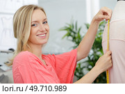 young fashion designer measuring garment on mannequin. Стоковое фото, агентство Ingram Publishing / Фотобанк Лори