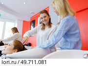teacher helping student to become hairdresser. Стоковое фото, агентство Ingram Publishing / Фотобанк Лори