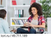 cheerful lady in wheelchair with cup of tea. Стоковое фото, агентство Ingram Publishing / Фотобанк Лори