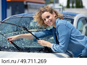 beautiful woman picking up windscreen wiper and checking it. Стоковое фото, агентство Ingram Publishing / Фотобанк Лори