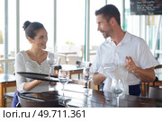 waiter and waitress interacting with each other at counter. Стоковое фото, агентство Ingram Publishing / Фотобанк Лори