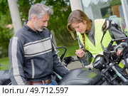 pretty female taking motorbike lesson with handsome teacher. Стоковое фото, агентство Ingram Publishing / Фотобанк Лори