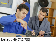 mechanic fixing the rear axle of the truck. Стоковое фото, агентство Ingram Publishing / Фотобанк Лори